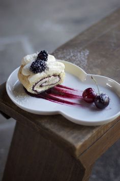 a piece of cake on a plate with berries