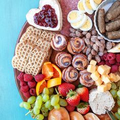 a platter filled with fruit, sausages, waffles and other foods