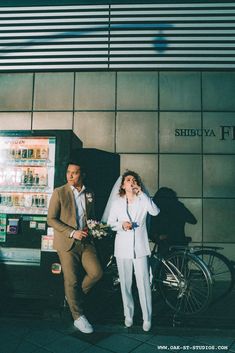 two people standing next to each other in front of a vending machine