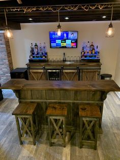 a bar with stools and a television on the wall