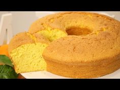 a bundt cake on a white plate next to an orange and green leafy plant