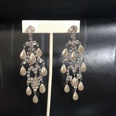 a pair of earrings is displayed on a stand