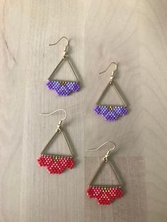 three pairs of beaded earrings hanging from hooks