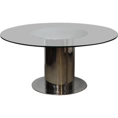 a round glass table with metal legs and a silver plate on the top, against a white background