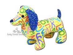 a toy dog made out of letters and numbers on it's back legs, sitting in front of a white background