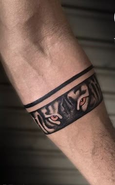 a man's arm with a tiger tattoo on the side of his arm and an eye in the middle