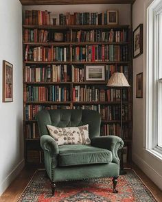 a green chair sitting in front of a book shelf filled with books