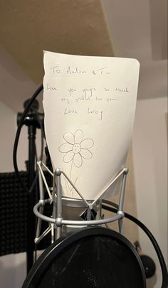 a piece of paper with writing on it sitting in front of a microphone and recording equipment