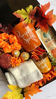 an open gift box filled with personal care products and autumn leaves on the table top