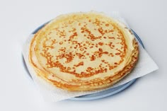 a stack of pancakes sitting on top of a blue plate next to a white napkin