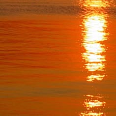 the sun is setting over the water and reflecting it's reflection in the water