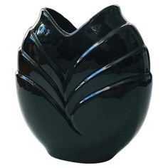 a black vase sitting on top of a white table