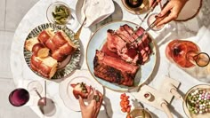 a table topped with plates filled with meat and veggies