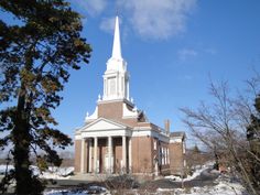 an old church with a steeple and snow on the ground