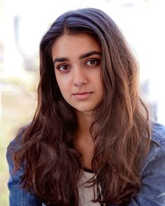 a girl with long hair is looking at the camera