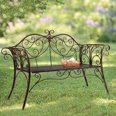 a metal bench sitting on top of a lush green field