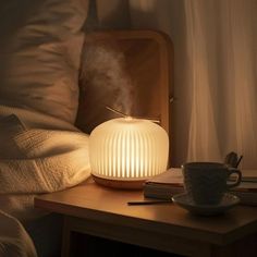 a white lamp sitting on top of a table next to a cup and saucer