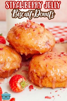 strawberry jelly biscuit donuts on a plate with strawberries next to it and the words, strawberry jelly biscuit donuts