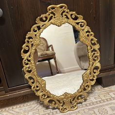 a mirror sitting on the ground in front of a dresser