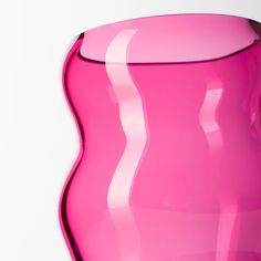 a pink vase sitting on top of a white table