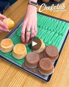 a person is decorating cupcakes on a tray