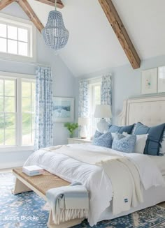 a bedroom with blue and white decor in the ceiling, windows, and bedding