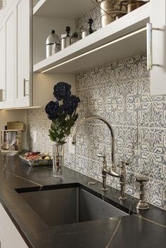 a kitchen sink sitting under a window next to a counter