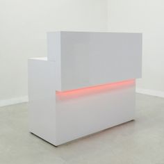 a white sculpture with red lights on it's sides in the middle of a room