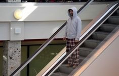 a man in pajamas is walking down an escalator