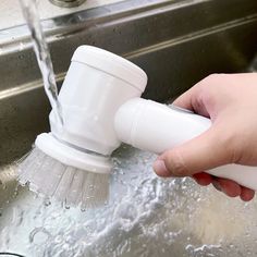 a person is washing their hands under a faucet