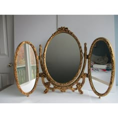 three round mirrors sitting on top of a white counter next to a door and window