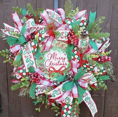 a christmas wreath hanging on the side of a wooden fence