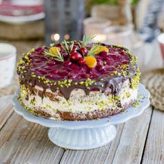 a cake sitting on top of a white plate covered in frosting and toppings