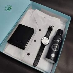 a white shirt and black watch in a blue box