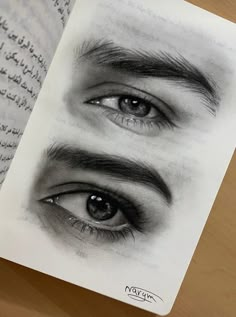 an open book with drawings of two eyes