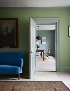 a living room with green walls and a blue couch