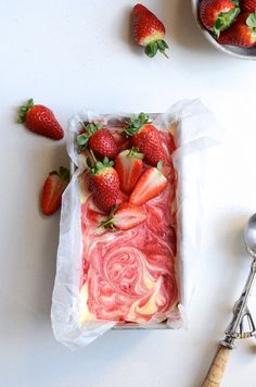 strawberries and other fruit are in plastic bags on a white surface with spoons