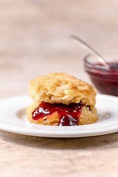 a close up of a plate of food with biscuits and jelly on it, text reads almond milk biscuits fluffy healthy light