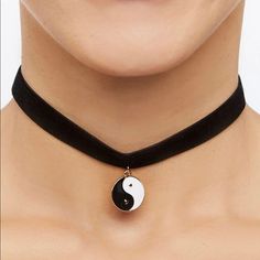 a woman wearing a black choker with a yin symbol on the front and bottom