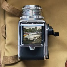 a camera attached to the back of a bag with a car on it's screen