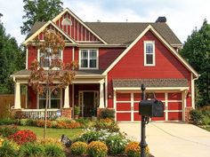 a red house with lots of flowers in the front yard