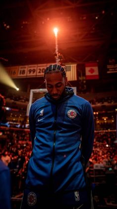 a man standing in front of a crowd wearing a blue jacket and headbands