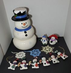 a snowman is surrounded by other ornaments