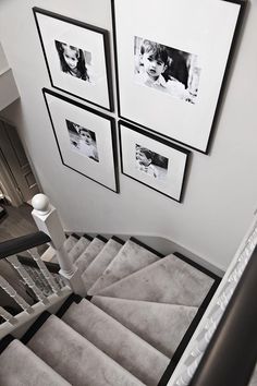 stairs with pictures hanging on the wall above them