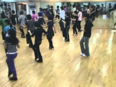 a group of people dancing in a large room