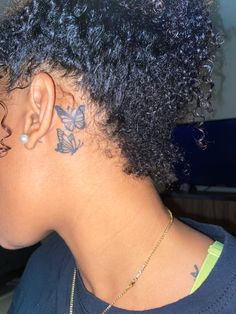 the back of a woman's head with tattoos on her neck and behind her ear