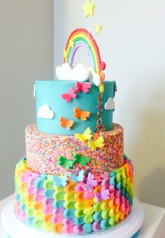 there is a multi layer cake decorated with rainbows and stars