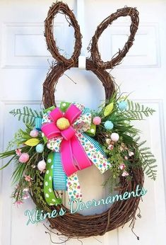 a wreath with an easter bunny's head hanging on the front door to welcome guests