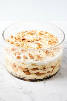 a layered dessert in a glass dish on a marble counter