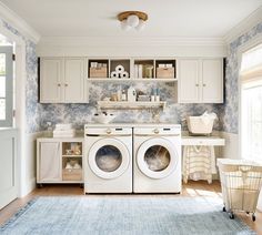 a washer and dryer in a room with blue wallpaper on the walls